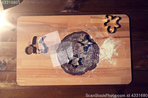 Image of close up of ginger dough, molds and flour on board