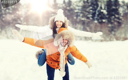 Image of happy couple having fun over winter background