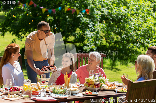 Image of happy family having dinner or summer garden party