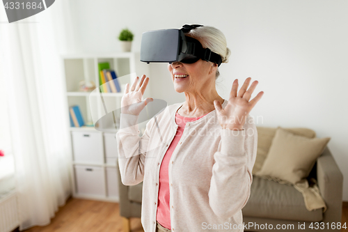 Image of old woman in virtual reality headset or 3d glasses