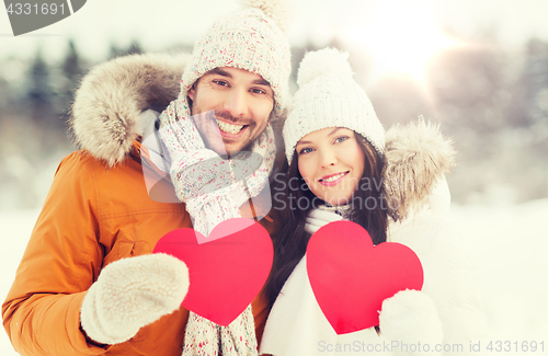 Image of happy couple with red hearts over winter landscape