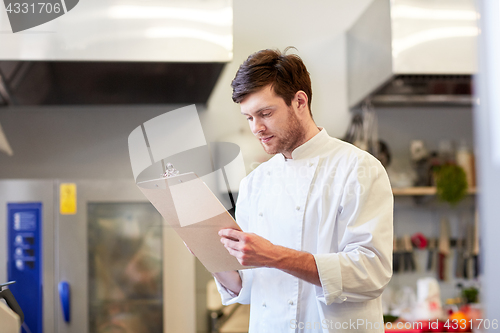 Image of chef with clipboard doing inventory at restaurant