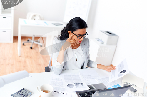 Image of businesswoman with laptop working at office