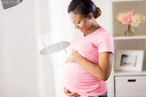 Image of happy pregnant woman with big belly at home