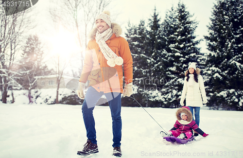 Image of happy family with sled walking in winter outdoors