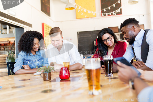 Image of friends with smartphone, tablet pc and beer at bar
