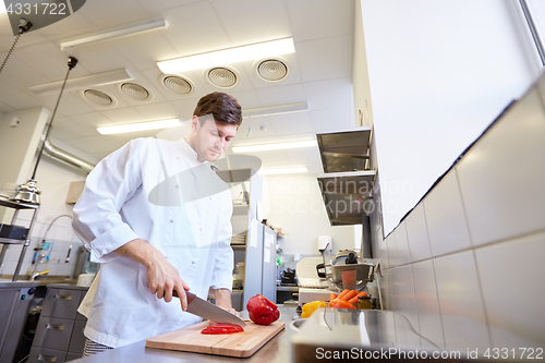 Image of happy male chef cooking food at restaurant kitchen