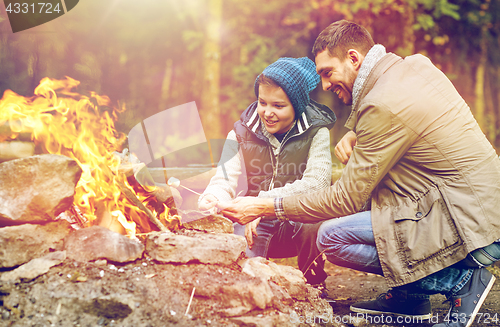 Image of father and son roasting marshmallow over campfire