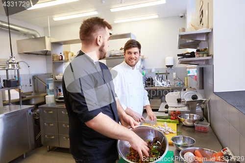 Image of chef and cook cooking food at restaurant kitchen