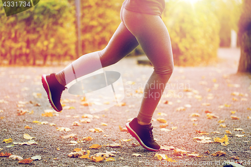 Image of close up of young woman running in autumn park