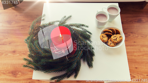 Image of close up of christmas wreath with candle on table