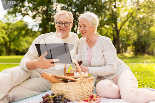 Image of happy senior couple having picnic at summer park