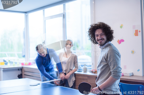 Image of startup business team playing ping pong tennis