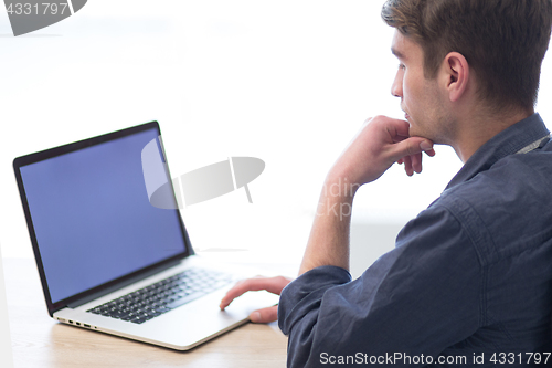 Image of businessman working using a laptop in startup office