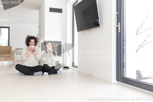 Image of happy multiethnic couple  in front of fireplace