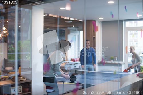 Image of startup business team playing ping pong tennis