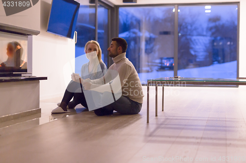 Image of happy couple in front of fireplace