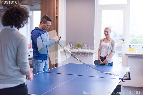 Image of startup business team playing ping pong tennis