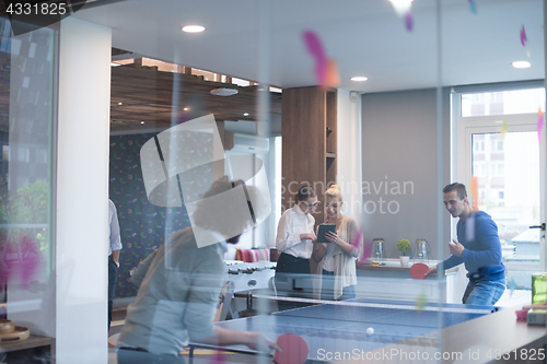 Image of startup business team playing ping pong tennis