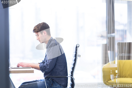 Image of businessman working using a laptop in startup office