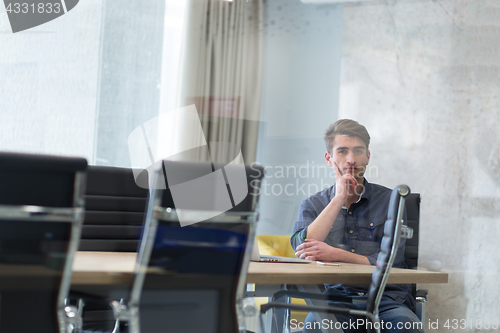 Image of Young casual businessman using smartphone