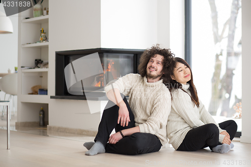 Image of happy multiethnic couple  in front of fireplace