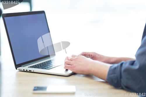 Image of businessman working using a laptop in startup office