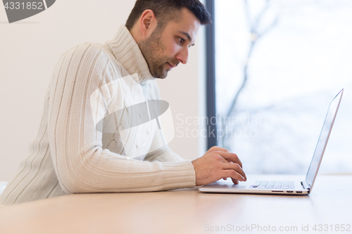 Image of businessman working using a laptop in startup office