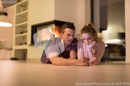 Image of Young Couple using digital tablet on cold winter night