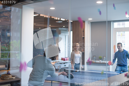 Image of startup business team playing ping pong tennis