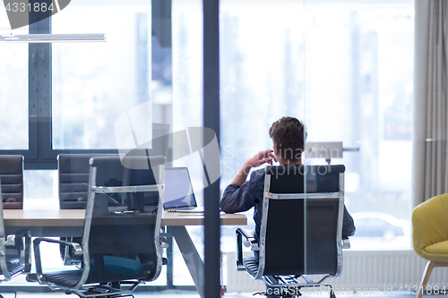 Image of young businessman relaxing at the desk