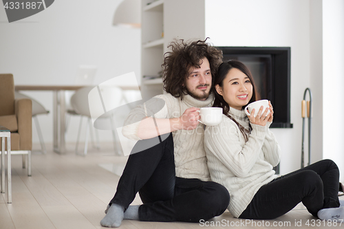 Image of happy multiethnic couple  in front of fireplace