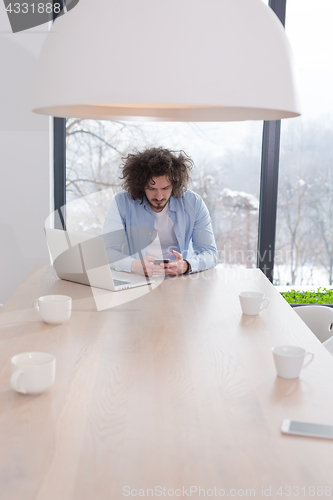 Image of Young casual businessman using smartphone