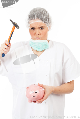 Image of a woman doctor breaks his piggy bank with a hammer