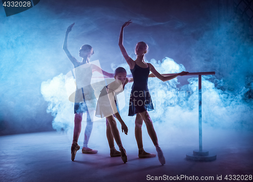 Image of The young ballerinas stretching on the bar