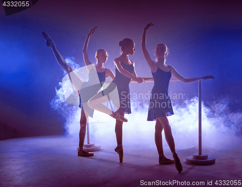 Image of The young ballerinas stretching on the bar