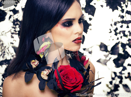 Image of pretty brunette woman with rose jewelry, black and red, bright m