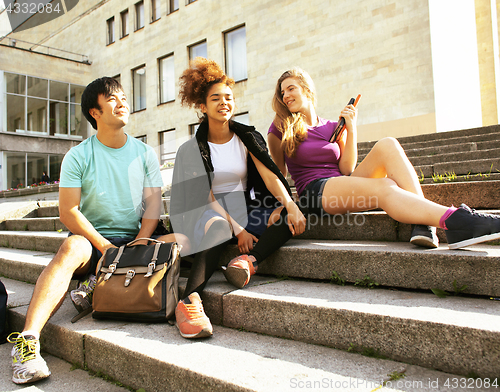 Image of cute group of teenages at the building of university with books 