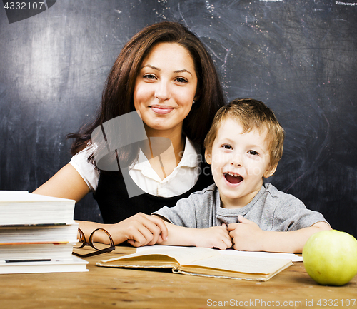 Image of little cute boy with teacher in classroom