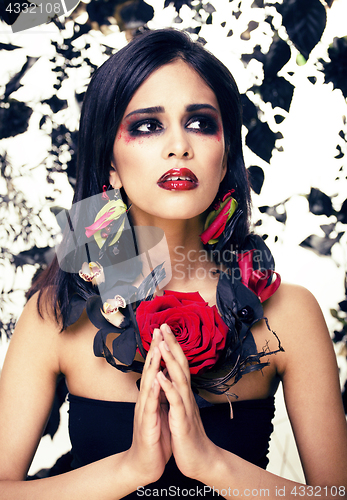 Image of pretty brunette woman with rose jewelry, black and red, bright m