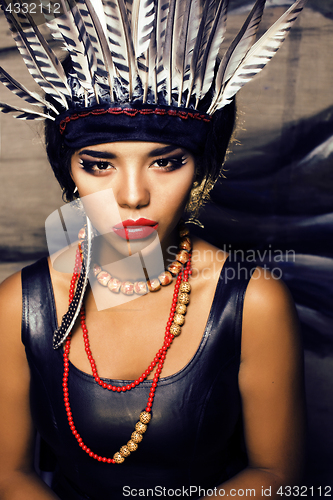 Image of young pretty woman with make up like red indian, futher in hair,