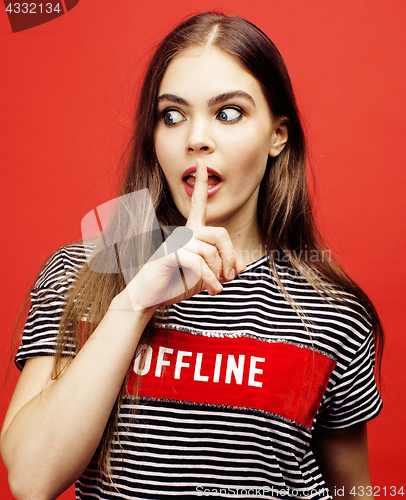 Image of young pretty emitonal posing teenage girl on bright red background, happy smiling lifestyle people concept 