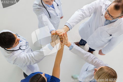 Image of group of doctors making high five at hospital