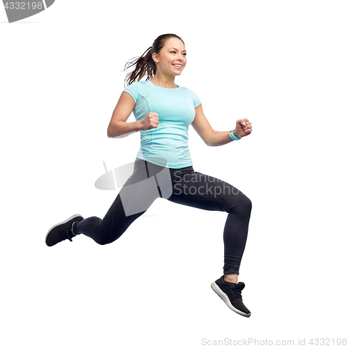 Image of happy smiling sporty young woman jumping in air