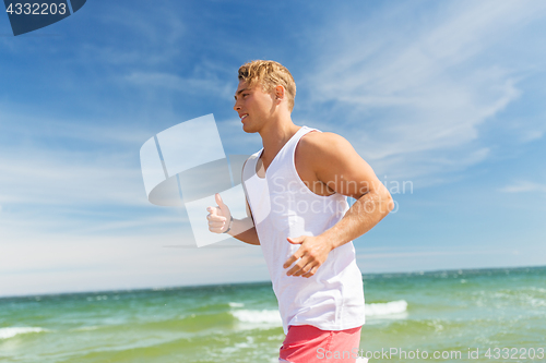 Image of happy man running along summer beach