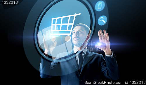 Image of businessman with shopping cart on virtual screen