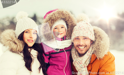 Image of happy family with child in winter clothes outdoors