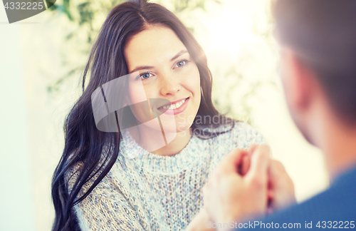 Image of happy couple holding hands at restaurant or cafe