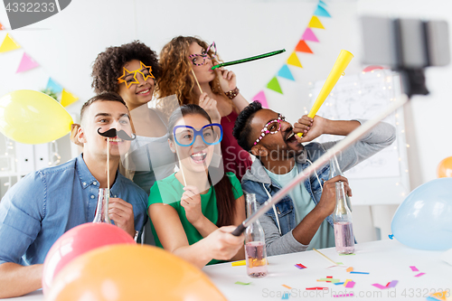 Image of happy team taking selfie at office party