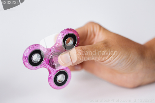 Image of close up of hand playing with fidget spinner